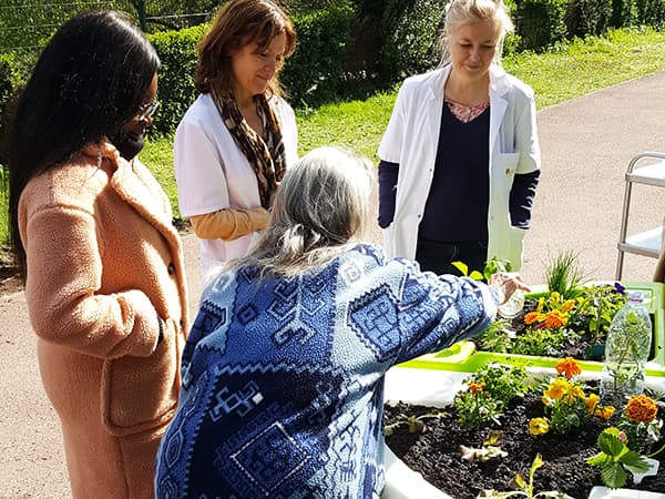 Roxandra arrose son jardin thérapeutique à l'hôpital Sainte-Périne 2019
