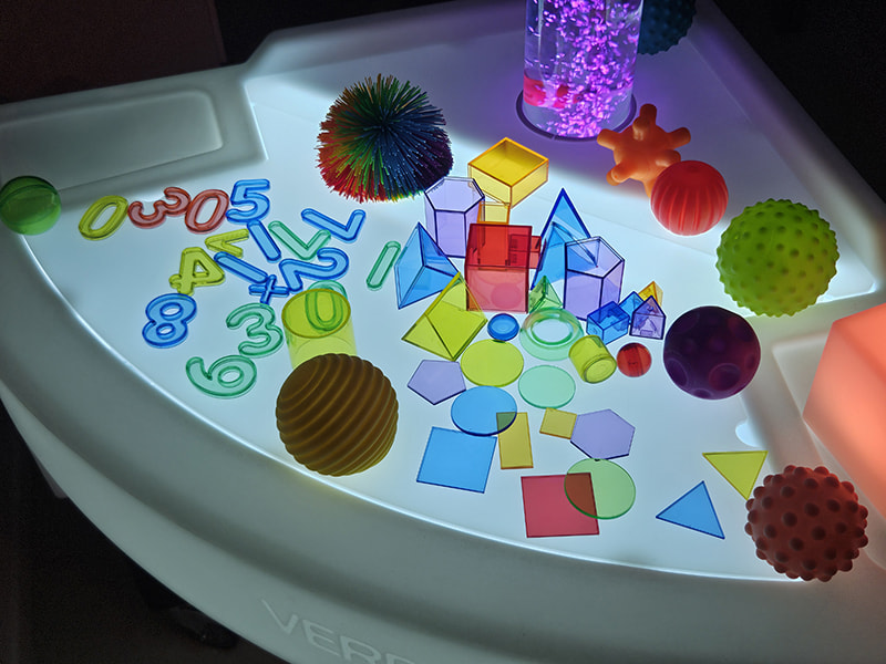 Pack éveil et formes Pack d'accessoires éducatifs et balles sensorielles pour table lumineuse.